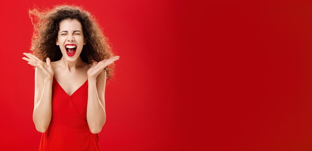 Foto gratuita mujer liberando estrés gritando en voz alta expresiva y sobreemocionada atractiva mujer de pelo rizado en
