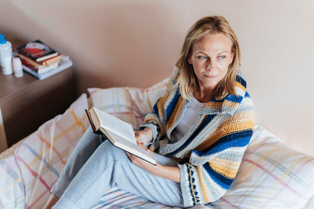 Mujer con libro en cuarentena en casa
