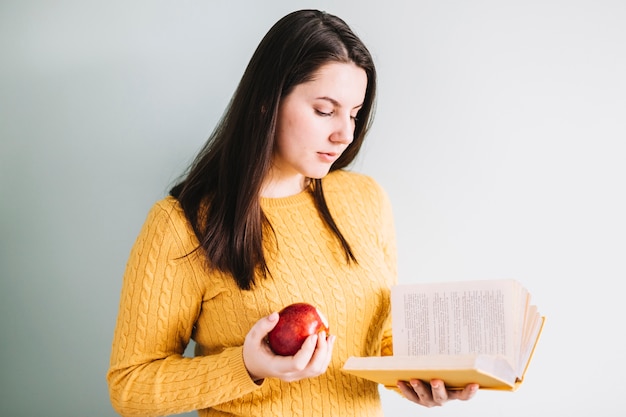 Foto gratuita mujer con libro de lectura de manzana