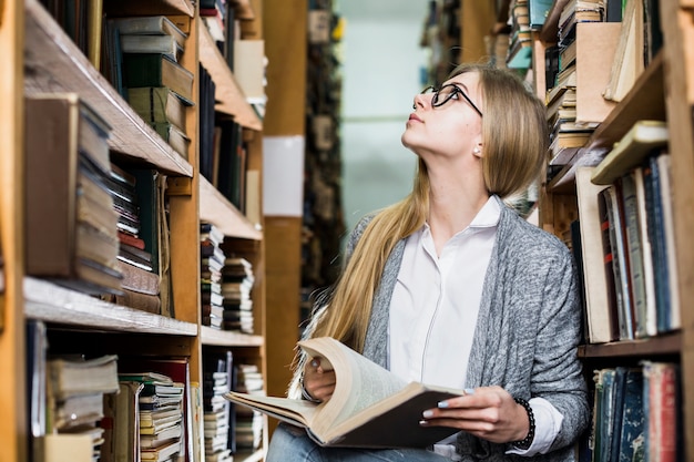 Mujer con libro mirando hacia arriba