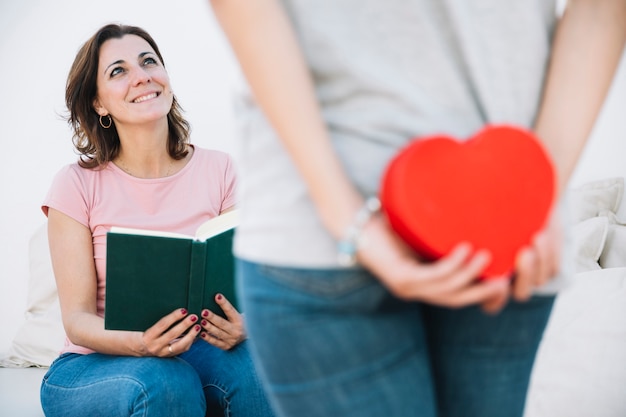 Mujer con libro mirando a mujer haciendo sorpresa