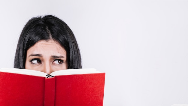 Mujer con libro mirando a otro lado