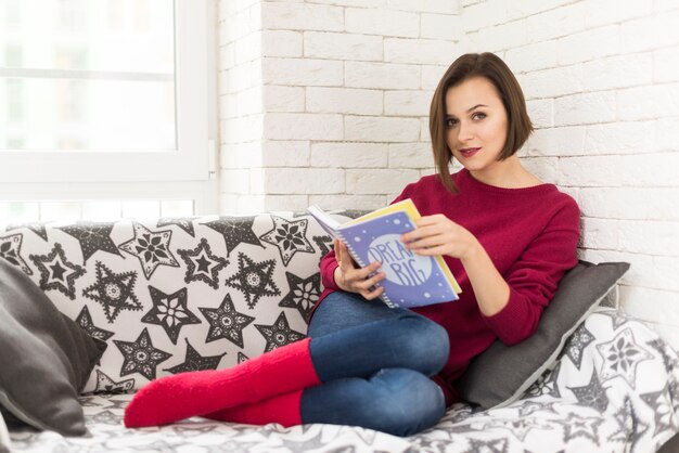 Mujer con libro en sofá