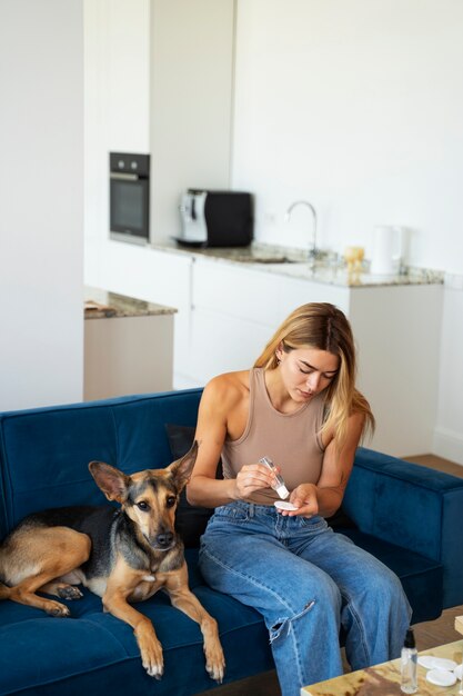 Mujer limpiando perro en casa plano medio