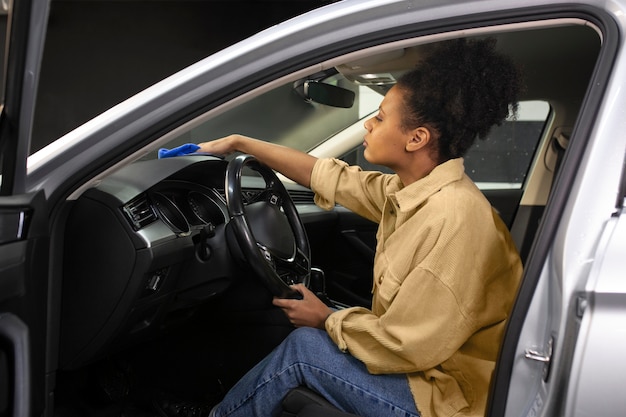 Mujer limpiando el salpicadero del coche