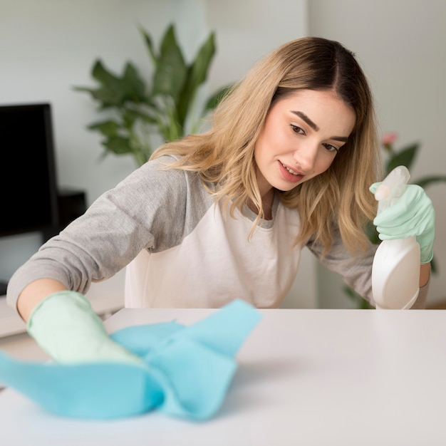 Mujer limpiando la superficie con solución y paño