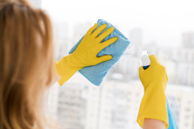 Mujer limpiando ventanas con un trapo