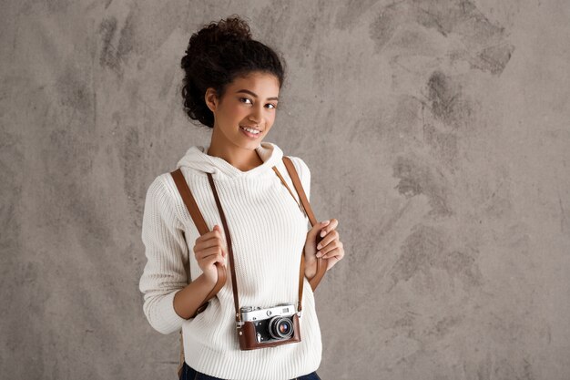 Mujer linda inconformista tomando fotos en cámara retro