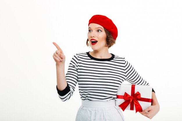 Mujer linda joven que sostiene la caja de la sorpresa del regalo.