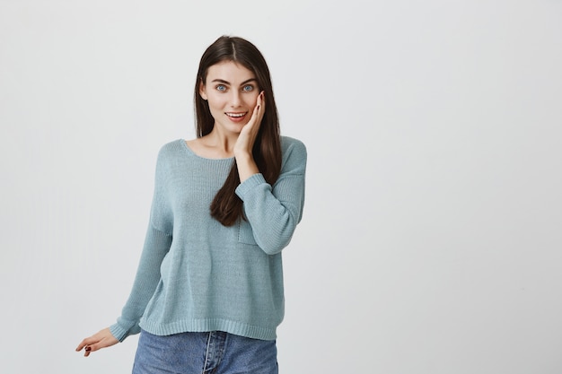 Mujer linda sorprendida sonriendo, mirando emocionado