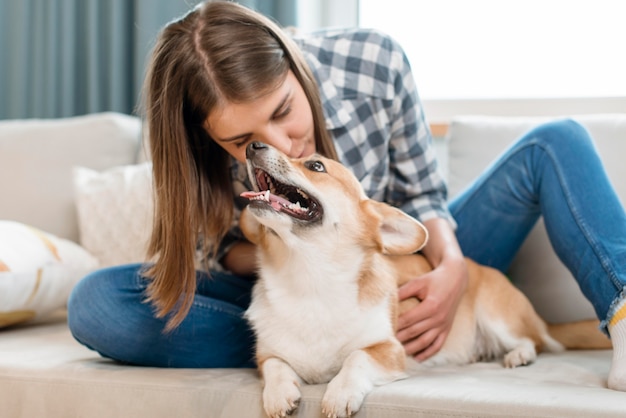 Mujer con lindo perro en el sofá