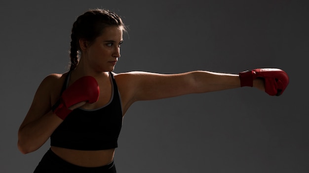 Mujer lista para golpear con guantes de box