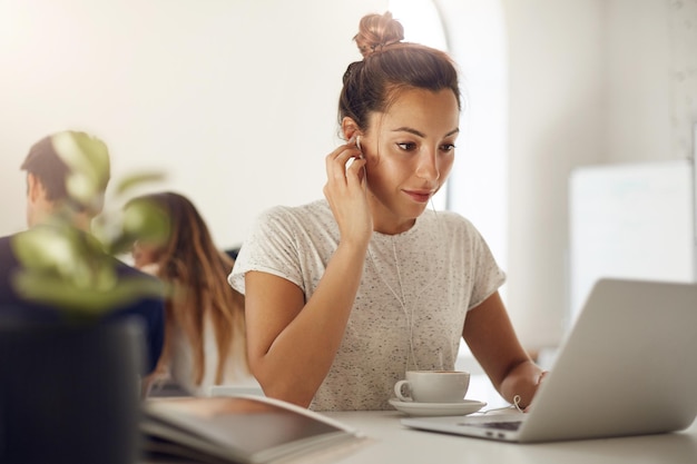 Mujer llamando a sus abuelos usando una computadora portátil y una plataforma de comunicación en línea sentada en un ambiente soleado adentro tomando café