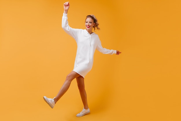 mujer llena de energía bailando en un cálido estudio