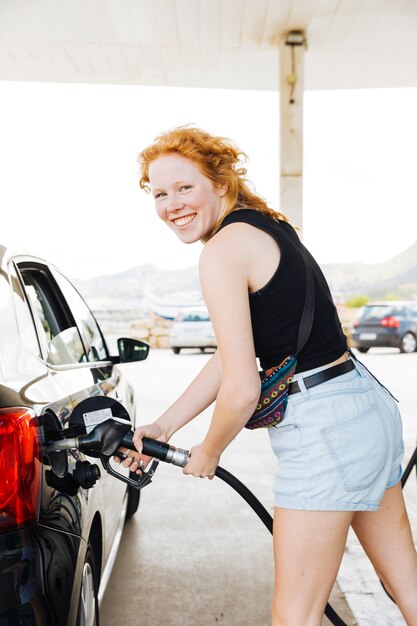 Mujer llenando el coche y sonriendo mirando a la cámara