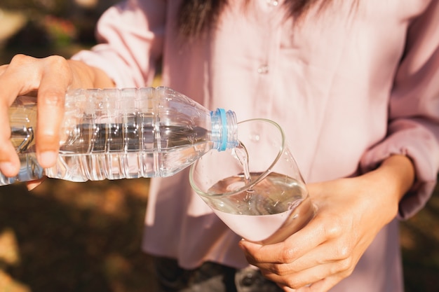 Foto gratuita mujer llenando un vaso de agua