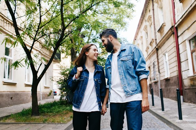 La mujer lleva a cabo la mano del hombre que camina con él en la vieja ciudad europea