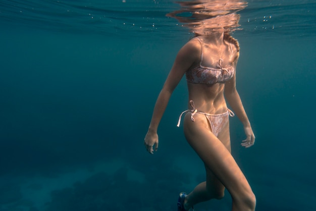 Mujer, llevando, biquini, como, nadar en el océano