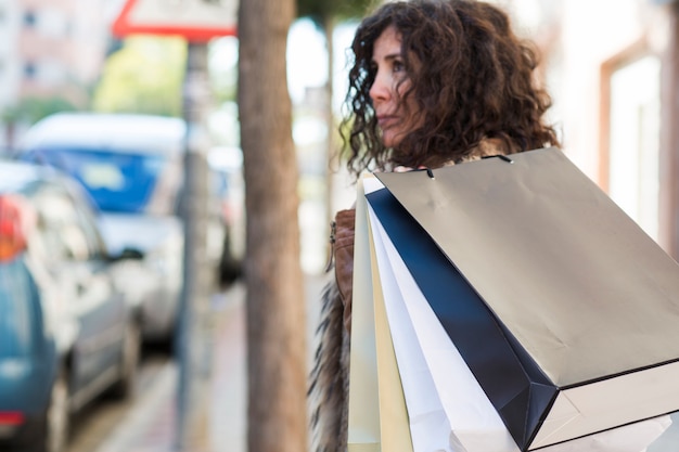 Mujer llevando bolsas de compras sobre el hombro