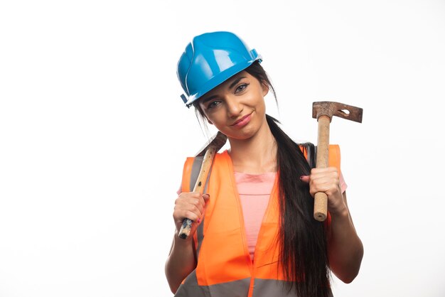 Mujer, llevando, en, chaleco, y, casco, tenencia, martillos