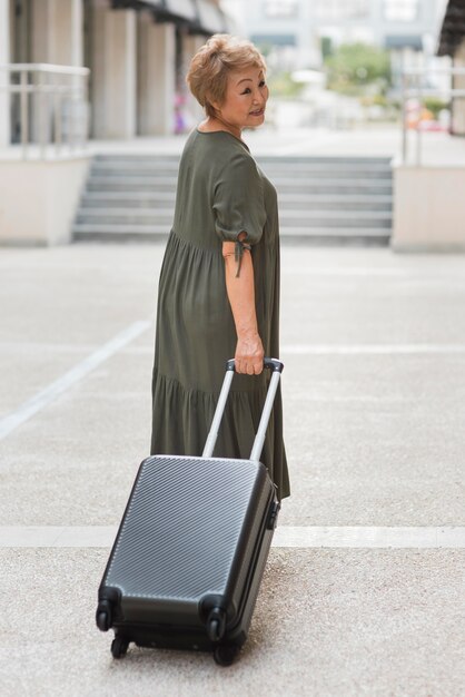 Mujer llevando equipaje de tiro completo