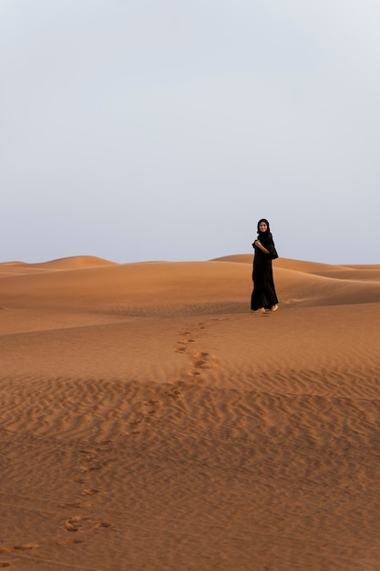 Foto gratuita mujer, llevando, hijab, en, el, desierto