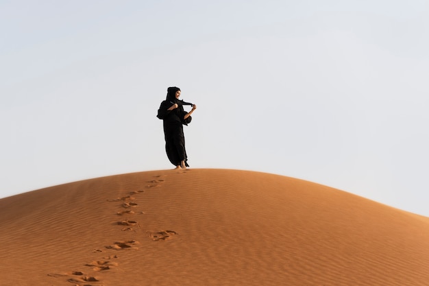 Foto gratuita mujer, llevando, hijab, en, el, desierto