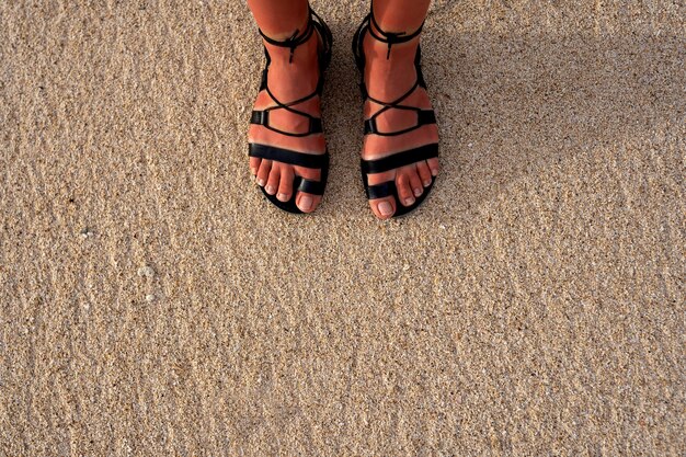 mujer, llevando, romano, sandalias, en la playa