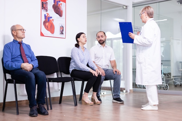 Mujer llorando mirando al médico después de noticias desfavorables en la sala de espera del hospital