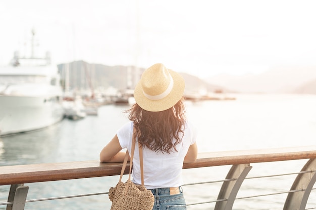 Mujer lookint en barcos en el mar