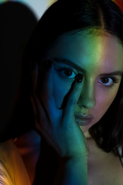 Foto gratuita mujer con luz de arco iris de cerca