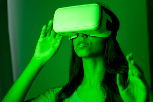 Foto gratuita mujer en luz verde con casco de realidad virtual