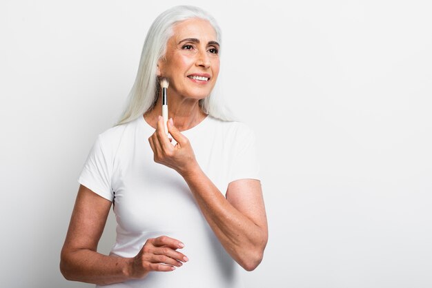 Mujer madura aplicando maquillaje