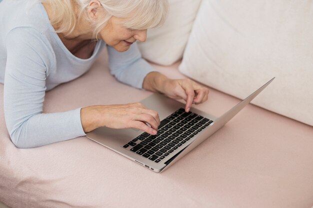 Mujer madura escribiendo en la computadora portátil