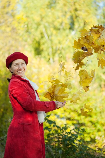 mujer madura feliz en el parque de otoño