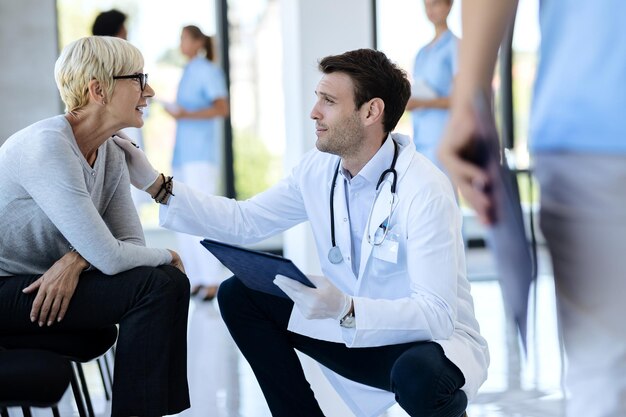Mujer madura hablando con un médico varón en la sala de espera del hospital
