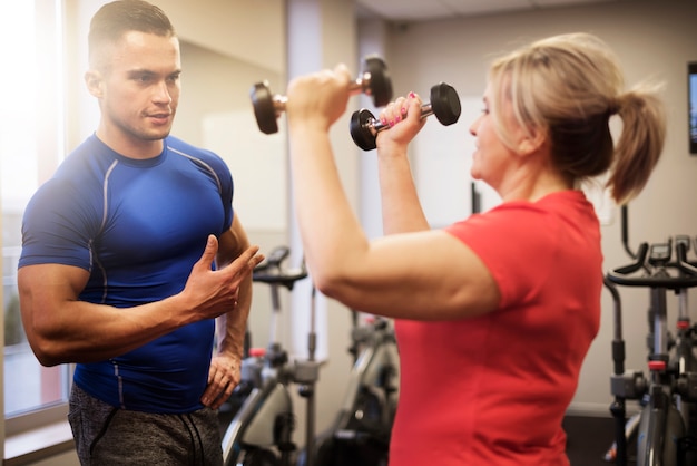 Mujer madura haciendo ejercicio con entrenador