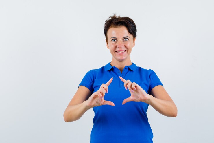 Foto gratuito mujer madura haciendo gesto de marco en camiseta azul y mirando feliz. vista frontal.