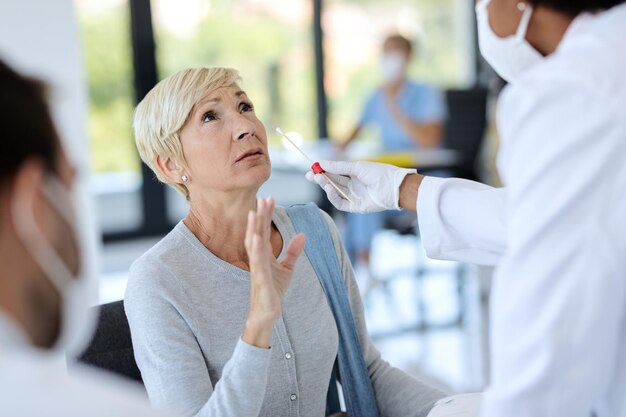 Mujer madura haciéndose la prueba del coronavirus en la clínica médica