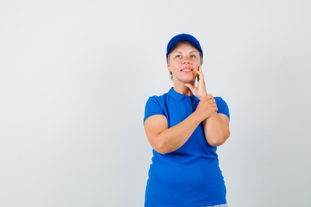 Foto gratuita mujer madura mirando hacia arriba en camiseta y mirando soñadora.