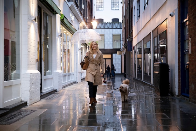 Mujer madura paseando a su perro mientras llueve