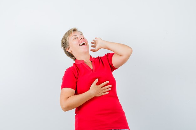 Mujer madura riendo a carcajadas en camiseta roja