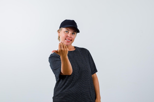 Foto gratuita mujer madura rubia con una camiseta negra y una gorra negra