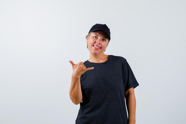 Mujer madura rubia con una camiseta negra y una gorra negra