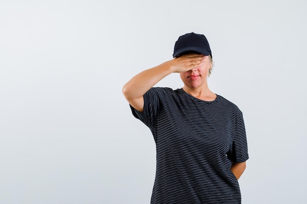 Foto gratuita mujer madura rubia con una camiseta negra y una gorra negra