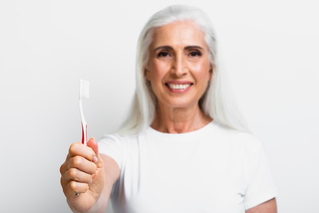 Mujer madura sonriente orgullosa de su cepillo de dientes