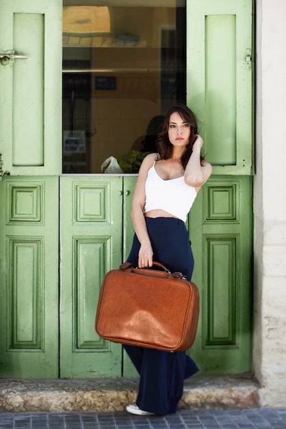 Foto gratuita mujer con una maleta marrón grande