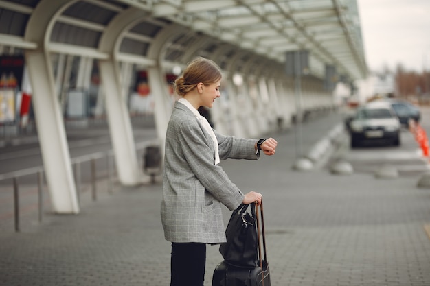 Mujer con maleta de pie en el aeropuerto