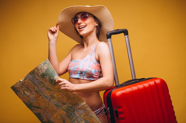 Mujer con maleta roja y mapa de viaje en un traje de baño aislado