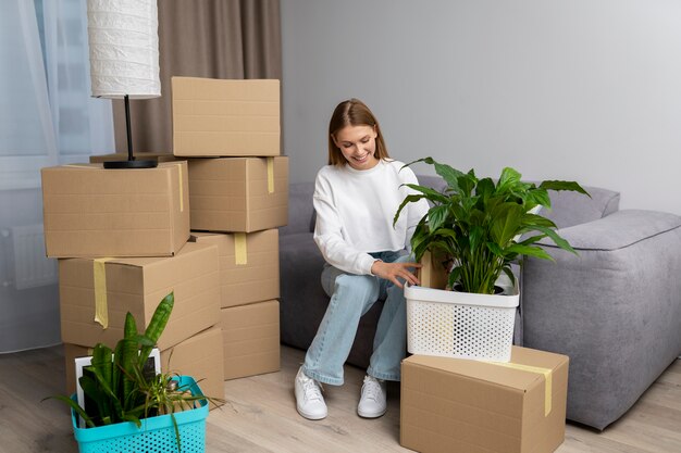 Mujer manejando pertenencias después de mudarse a una casa nueva